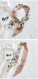Detail of slim silk twilly with yellow pineapple print and blue script on khaki background