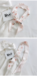 Detail of narrow pink scarf with peach print and artistic lettering for bag or hair