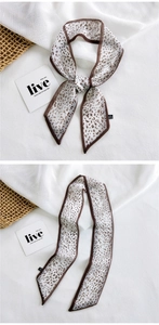 Detailed close-up of leopard print skinny scarf showing sheer fabric texture and edges