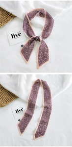 Detailed view of leopard print silk scarf tied as a luxury accessory for bags and hair
