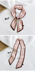Detail of light pink twilly scarf with brown heart pattern for bags or hair