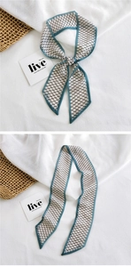 Detail of skinny scarf with black dotted patterns, teal contrast edging and soft texture