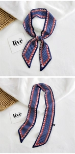 Detail of blue narrow scarf with red floral edges and geometric pattern for bag or hair