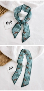 Detail of silk satin scarf with horse print and geometric patterns in teal and brown
