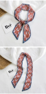Detailed pattern of the floral and geometric silk twilly scarf tied in a bow