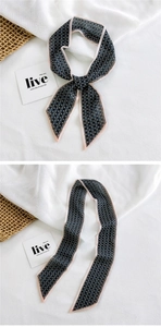 Detail of floral printed narrow twilly scarf showing pattern and contrast border