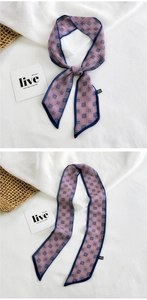 Detailed view of long narrow purple silk scarf with blue geometric square pattern