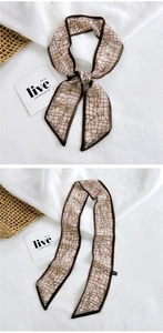Detail of silk scarf showing geometric lattice pattern on beige fabric and brown border