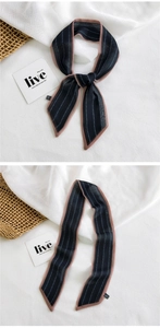 Detail of narrow black silk scarf with pink border and letter print tied on bag