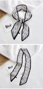 Detail view of long printed silk scarf with black dash pattern and rolled edges