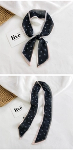 Close-up of black heart print narrow silk scarf with pink edges and bow detail