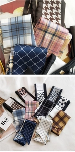 Detailed close-up of varied patterned narrow twilly scarves with fashion lettering