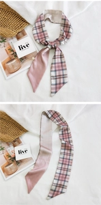 Detailed view of pink plaid silk scarf and satin texture on soft white fabric