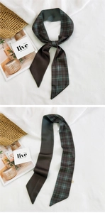 Detail of a plaid and solid brown spliced narrow silk scarf tied in an elegant bow