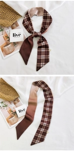 Detail of brown plaid silk scarf tied on a straw bag with elegant French style