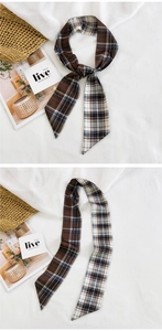 Detail of plaid skinny scarf with brown check pattern tied on a straw bag and flat lay
