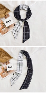 Macro detail of black and white checkered silk skinny scarf used as a bag accessory