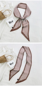 Detailed view of long brown and white chevron silk scarf tied on a white shirt