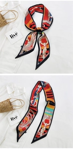 Macro shot of long silk scarf tied on a straw bag with vintage horse harness patterns