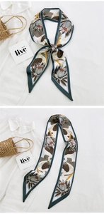Detail of silk narrow scarf with crane and lotus print tied on a handbag handle