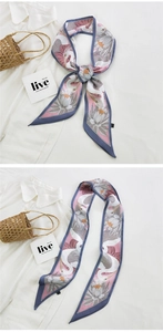 Macro detail of silk scarf featuring crane and lotus prints tied on a bag handle