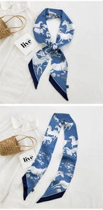Detail of dark blue skinny silk scarf with white horse pattern tied on a white shirt
