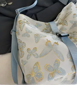 Detail of floral butterfly embroidery on white fabric with blue nylon strap buckle