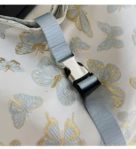 Close-up of premium silver hardware buckle and butterfly embroidery on the shoulder bag