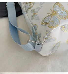Detail of silver hardware buckle and butterfly pattern on stylish canvas tote bag
