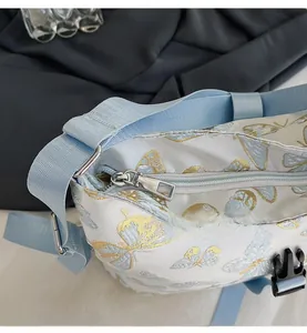 Detail of white nylon bag showing smooth silver zipper and blue printed butterfly patterns