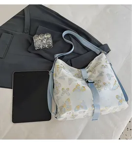 Detail of printed white shoulder bag with blue butterfly pattern and large capacity