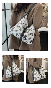 Detail of printed butterfly pattern large shoulder bag with adjustable black strap