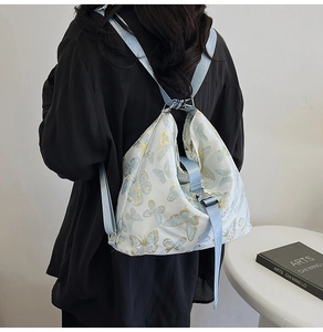 Detailed view of lightweight drawstring backpack featuring blue and gold butterfly prints