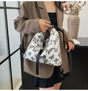 Detail of white crossbody bag with vintage gold butterfly prints and nylon strap