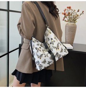 Detail of printed crossbody bag with butterfly patterns and adjustable black strap