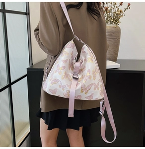 Detail of floral butterfly print on a white stylish crossbody bag with pink woven strap
