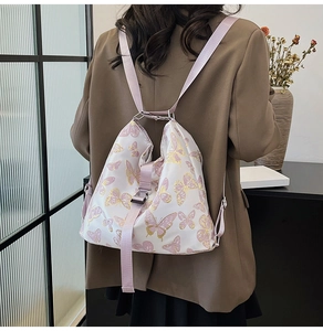 Detail of printed butterfly backpack with pink nylon strap and metal buckle on model