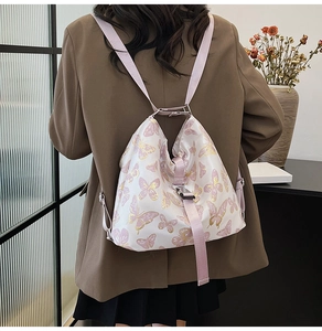Detail view of printed butterfly backpack with pink adjustable straps on a model back