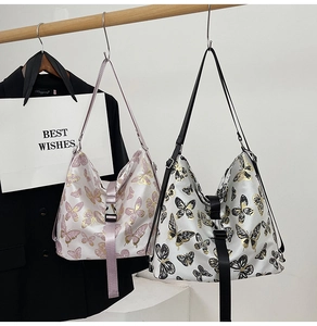 Detail of printed butterfly tote bags with adjustable straps and front buckle closure