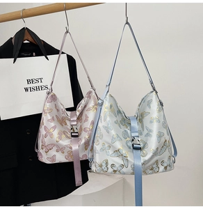 Detail of hobo shoulder bag featuring butterfly prints and adjustable buckle straps