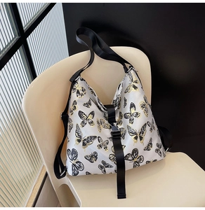 Close-up of butterfly print tote with nylon shoulder strap and adjustable buckle detail