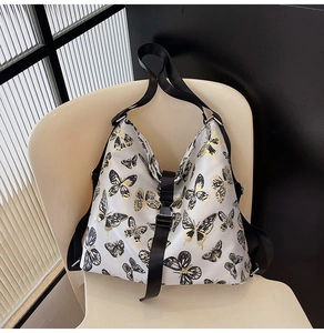 Detail of a large printed shoulder bag with butterfly patterns on a designer wooden chair