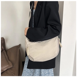 Detail van beige halve maan tas met gevlochten koordrits en nylon textuur opname