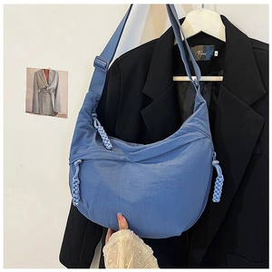 Detail van blauwe nylon halve maantas met geknoopte ritsen en verstelbare riem