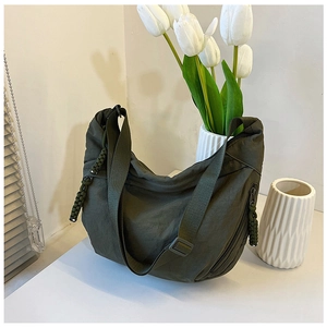 Detail van de olijfgroene nylon halve maantas met verstelbare riem en trekkoordsluiting
