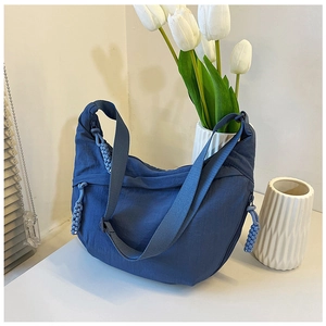 Detail van de donkerblauwe nylon halve maantas met verstelbare riem en geweven trekker