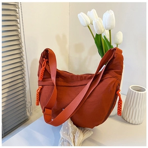 Detail van oranje nylon halvemaanvormige tas met unieke geweven kralenritsen