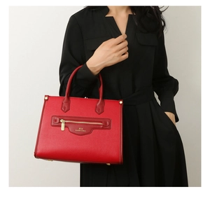 Detailansicht der strukturierten roten Leder-Einkaufstasche mit Goldlogo und Reißverschluss