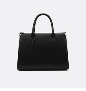 Detailansicht der schwarzen Leder-Tote-Bag mit Litschi-Struktur und goldenen Nietenakzenten