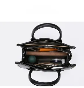 Draufsicht auf das geräumige Innenleben der schwarzen Ledertasche mit vielen Fächern